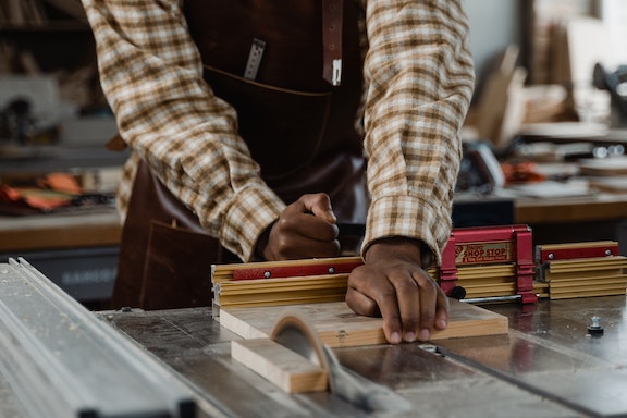 contractor using a table saw to cut a piece of wood